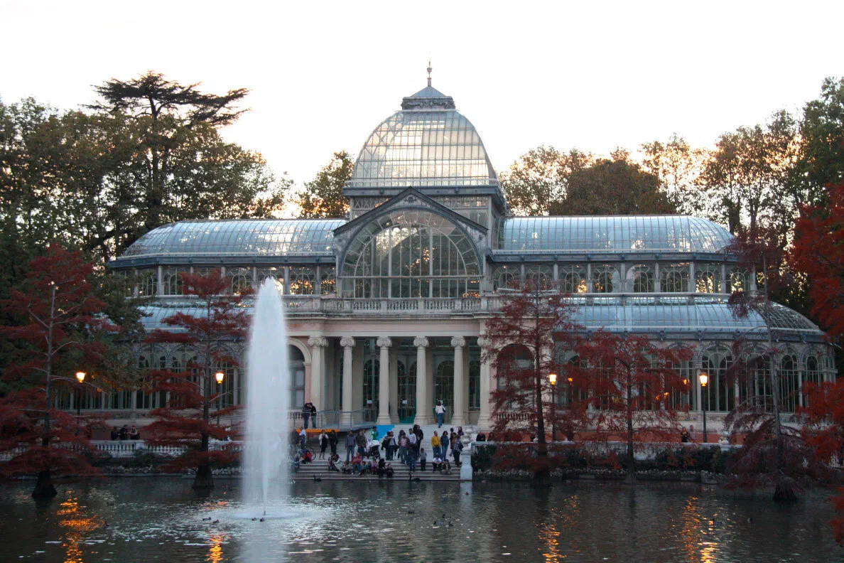El Palacio de Cristal del Retiro al atardecer, con la fuente delante
