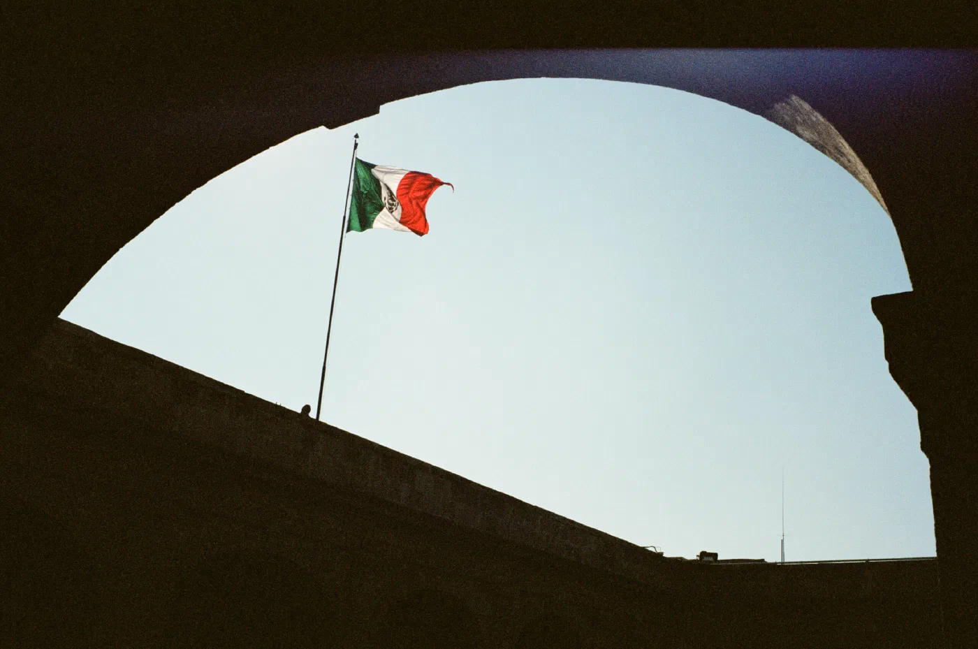 Mexican flag framed by a building